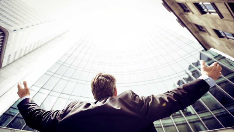 low-angle photography of man in the middle of buidligns